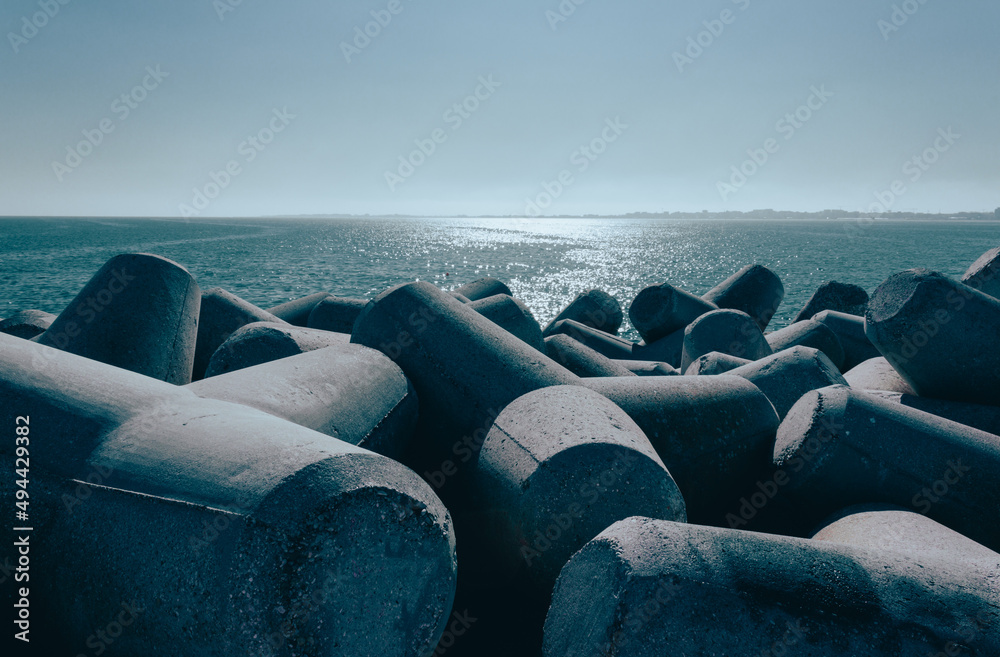 View from the Diga Sottomarina pier. Concrete breakwater with the blue sea background meeting the horizon. Seascape. - obrazy, fototapety, plakaty 