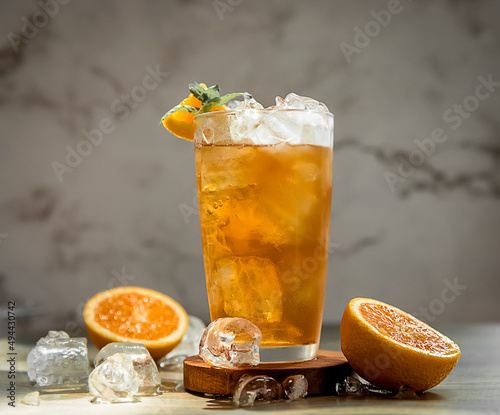fresh home made orange lemonade or kombucha in tall glass over grey background, healthy eating, detox, wellbeing concept