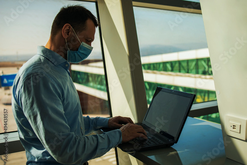 Passenger businessman wear masks covid19 disease prevention and Teleconference with laptop while traveling to work abroad at the airport terminal. New normal and Business trip concept