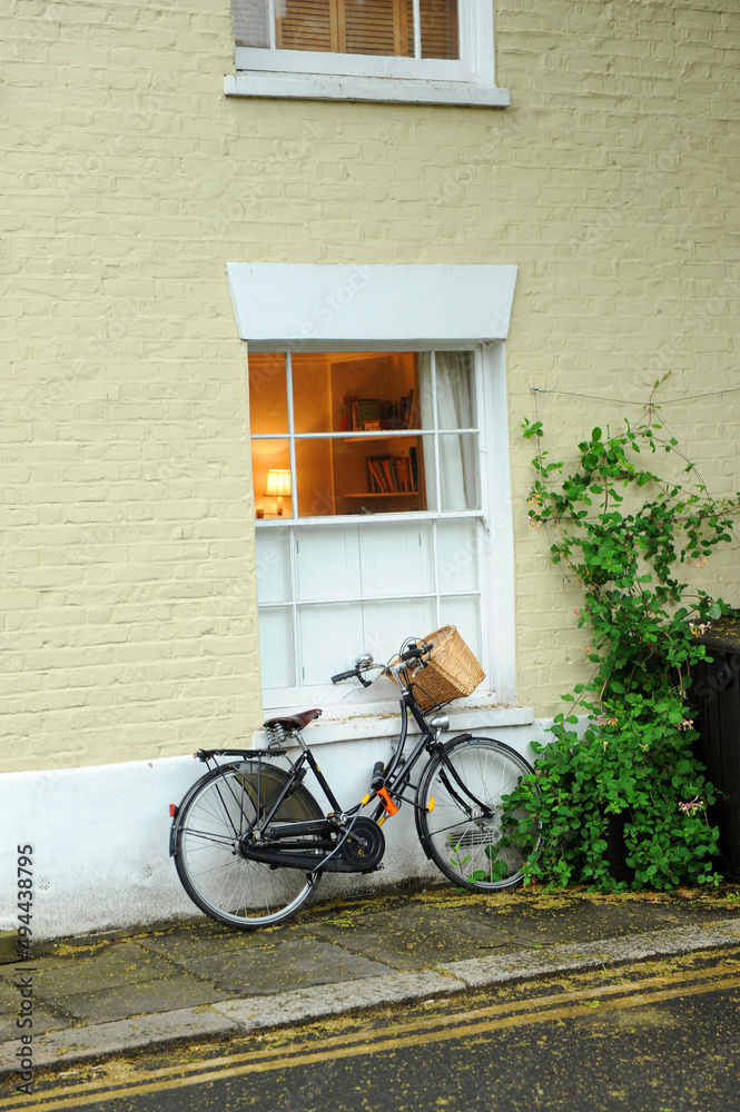 Bicycle with wicker basket in a brick house in the neighborhood of Fulham. London, United Kingdom