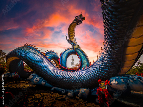 Naga with sunset time on Background Nage head in Buddhist art at Phu manorom temple mukdahan Province, Thailand