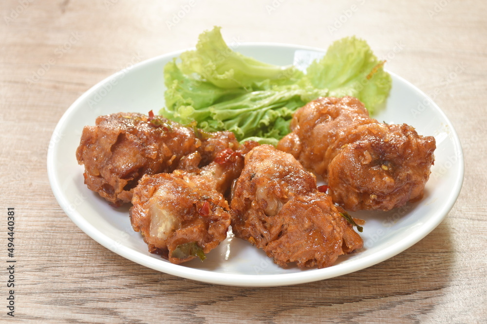 spicy crispy fried chicken drum wing with lemon leaf sauce and vegetable on plate spicy crispy fried chicken drum wing with lemon leaf sauce and vegetable on plate