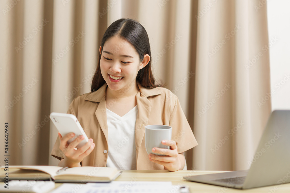 Online lifestyle concept A working woman sitting at her desk while updating new feeds on the social media. Online lifestyle concept A working woman sitting at her desk while updating new feeds on the social media.