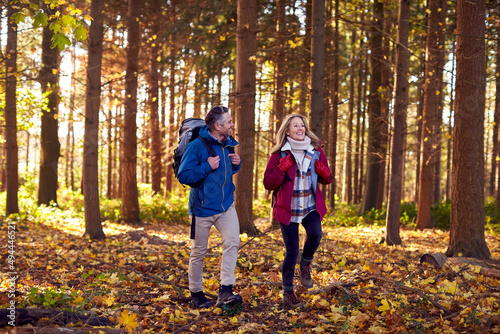 Mature Retired Couple With Backpacks Walking Through Fall Or Winter Countryside