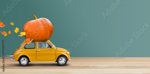 Thanksgiving is coming. Yellow car is carrying a pumpkin photo