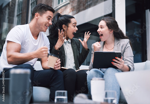 Every win adds up. Shot of a group of excited young businesspeople using a digital tablet during a meeting at a conference.