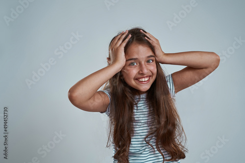 Cropped of caucasian little girl touching her head