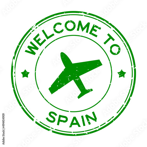 Grunge green welcome to Spain word with airplane icon round rubber seal stamp on white background