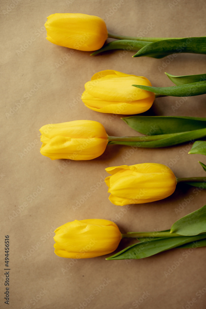 Obraz premium beautiful bouquet of yellow tulips on craft paper. gifts for moms, spring holidays, March 8 and February 14. Flowers packaging