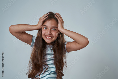 Partial image of little girl touching her head