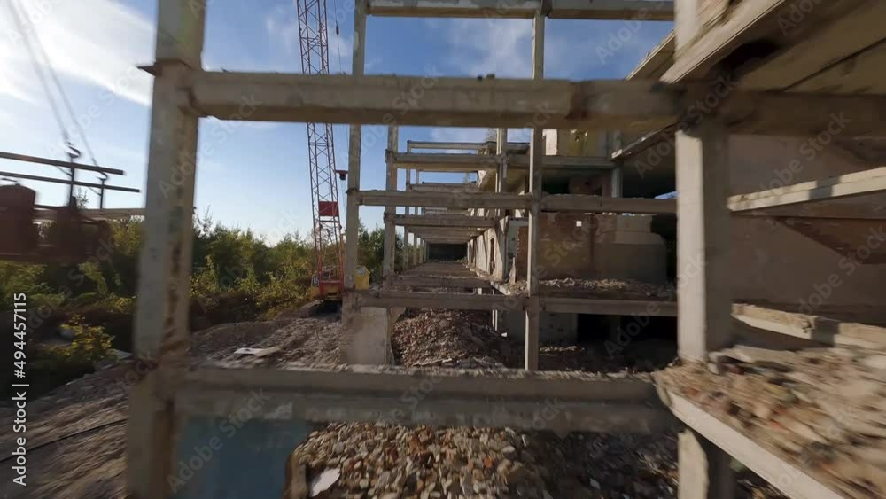 FPV drone flies quickly and maneuverable among abandoned industrial buildings and around an excavator. FPV drone flies quickly and maneuverable among abandoned industrial buildings and around an excavator.