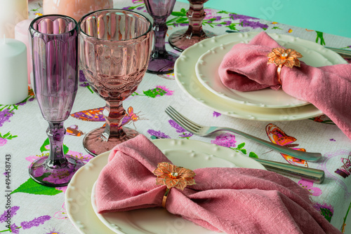 Table setting, white plates with pink napkins