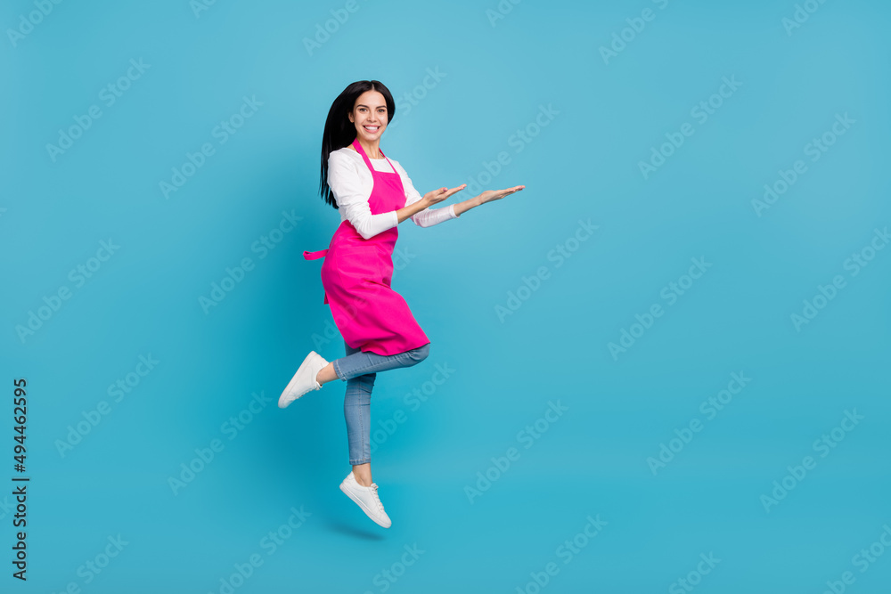 Full length body size view of beautiful cheery trendy girl hairdresser jumping holding copy space isolated on bright blue color background Full length body size view of beautiful cheery trendy girl hairdresser jumping holding copy space isolated on bright blue color background