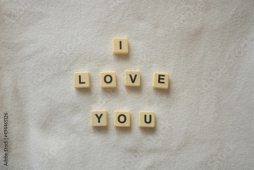 I love you written with scrabble / banagram block letters on soft white fleece background