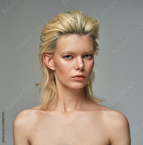 Portrait of beautiful blonde woman over gray background