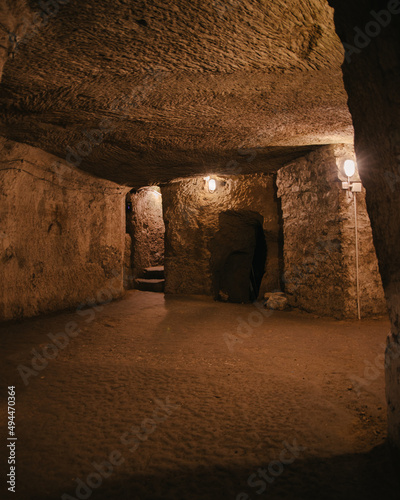 Fotografija Vertical shot of an underground city or catacomb corridor wirth stone walls and