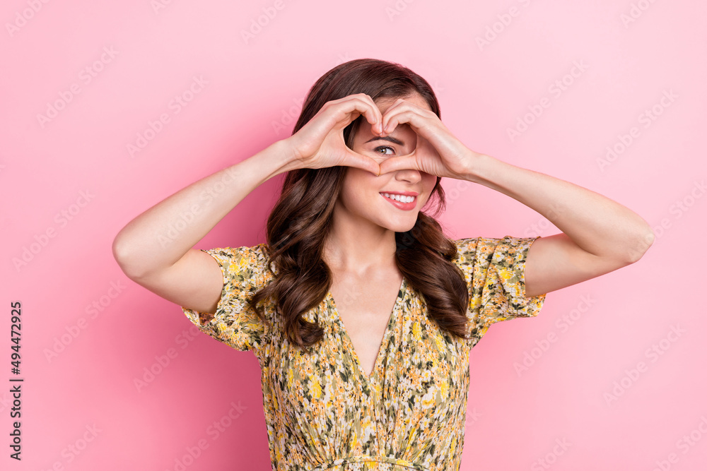 Photo of adorable positive lady arms fingers make heart gesture eye look camera isolated on pink color background Photo of adorable positive lady arms fingers make heart gesture eye look camera isolated on pink color background