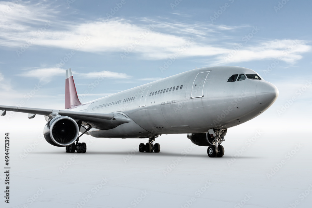 White wide body passenger airliner isolated on bright background with sky White wide body passenger airliner isolated on bright background with sky