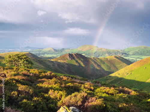 Scenic view of a rainbow on the green Long Mynd, Shropshire, England photo