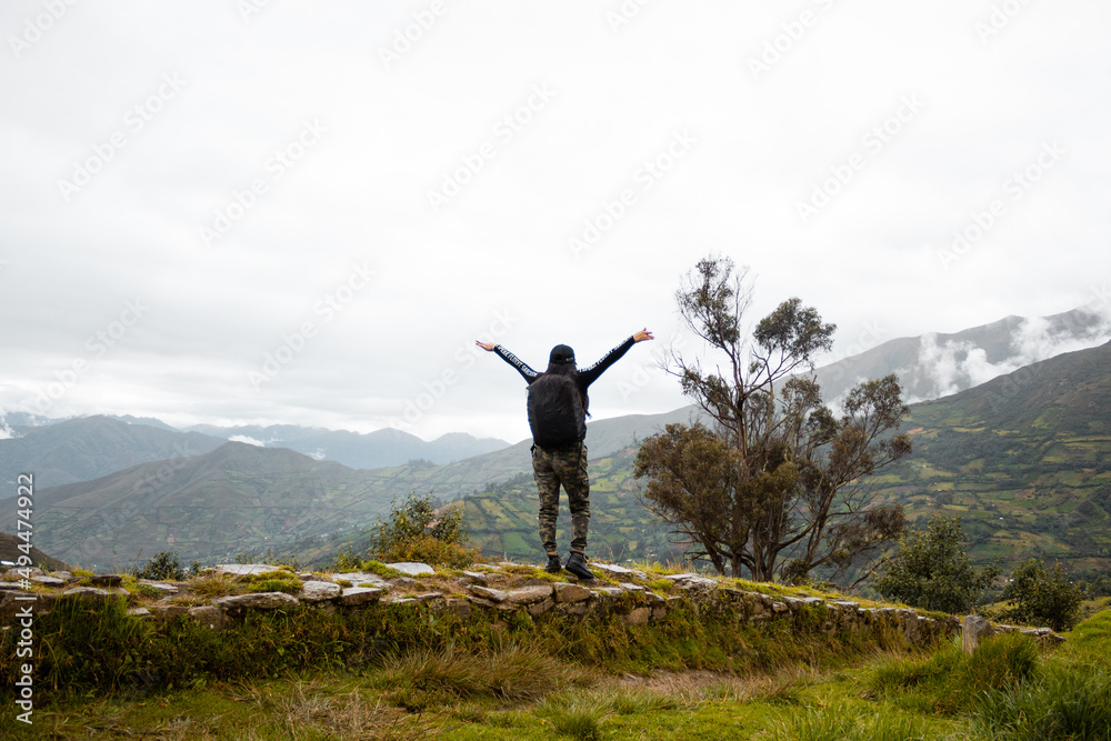 Mujer joven turista con mochila mirando el paisaje, Perú sobre hermosos acantilados de fondo. Viajes, estilo de vida activo y concepto de vacaciones de invierno. Mujer joven turista con mochila mirando el paisaje, Perú sobre hermosos acantilados de fondo. Viajes, estilo de vida activo y concepto de vacaciones de invierno.