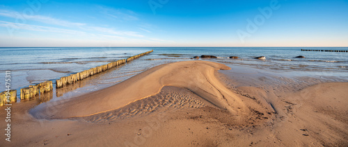 Fototapeta Naklejka Na Ścianę i Meble -  Sonniger Wintertag am Meer, Unberührter Strand mit Sandbank, Buhnen und Findlingen an der Ostsee