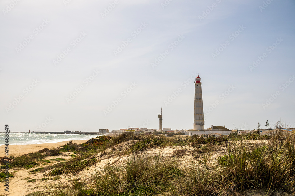 Beach, dunes and lighthouse at Farol Island, Faro, Algarve, Portugal Beach, dunes and lighthouse at Farol Island, Faro, Algarve, Portugal