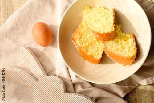 Plate of traditional sweet bread, eaten at Easter time in Croatia. Easter bunny, eggs and flowers on the table. Top view. photo