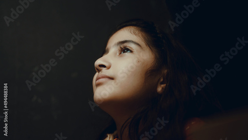 little girl doing homework in the dark