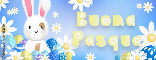 Italian yellow text : Buona Pasqua, with a cute white rabbit behind colored eggs and flowers on a blue background