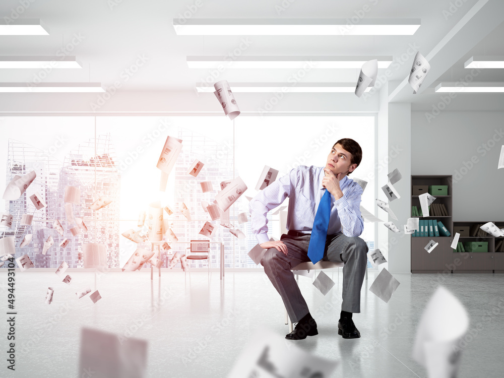 Young businessman sitting on an office chair Young businessman sitting on an office chair