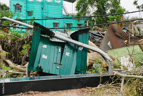 Howrah, West Bengal, India - 31st May 2020 : Super cyclone Amphan uprooted tree which fell , broke houses and blocked pavement. The devastation has made many trees fall on ground. photo
