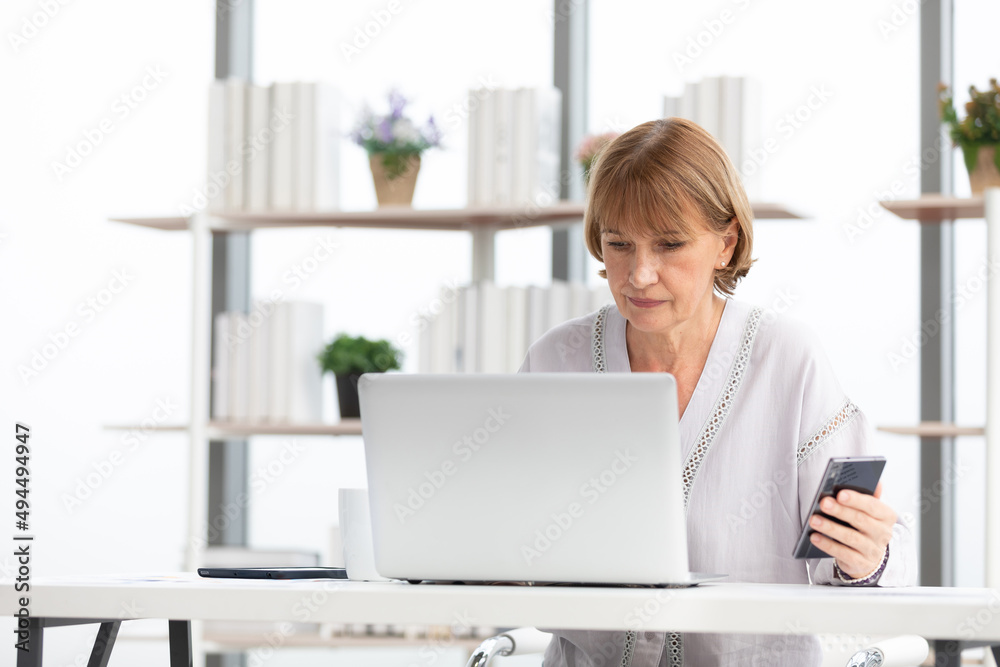 Fototapeta premium senior businesswoman or freelancer looking smartphone for checking something for work