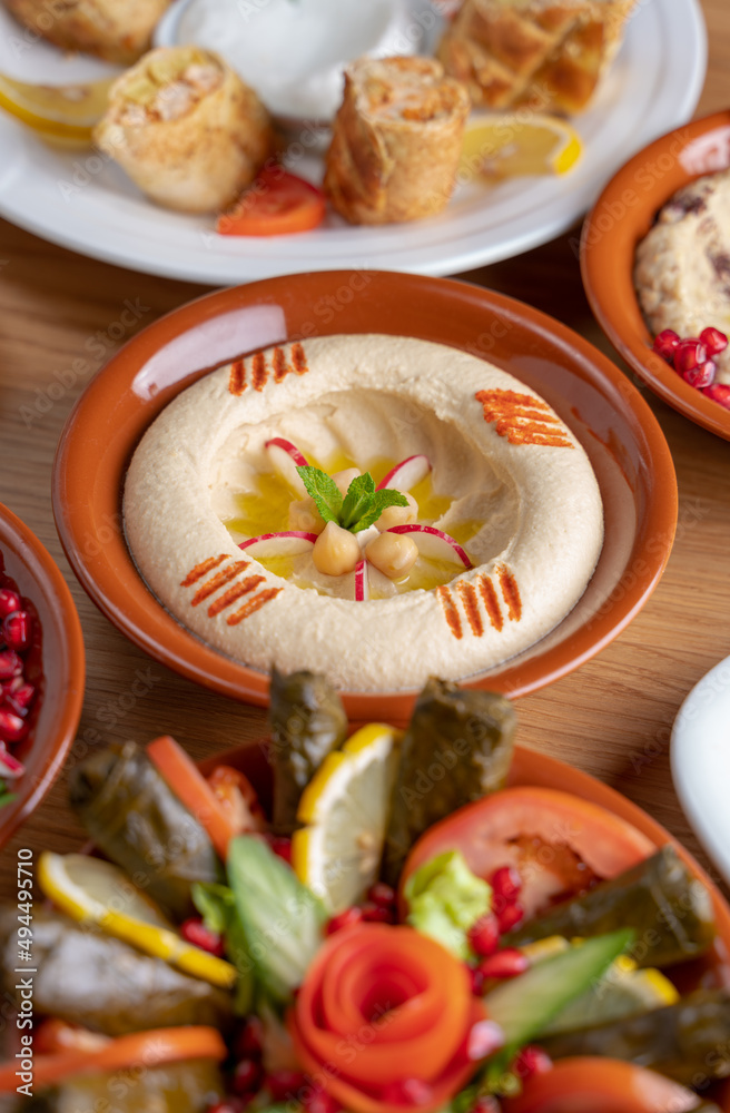 Multiple lebanese appetizers and salads togeather on the table. focused on hummus