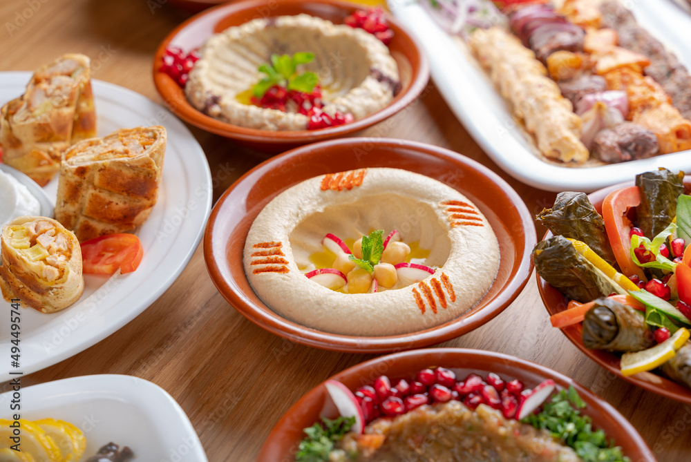 Multiple lebanese appetizers and salads togeather on the table. focused on hummus Multiple lebanese appetizers and salads togeather on the table. focused on hummus