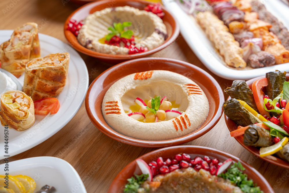 Multiple lebanese appetizers and salads togeather on the table. focused on hummus