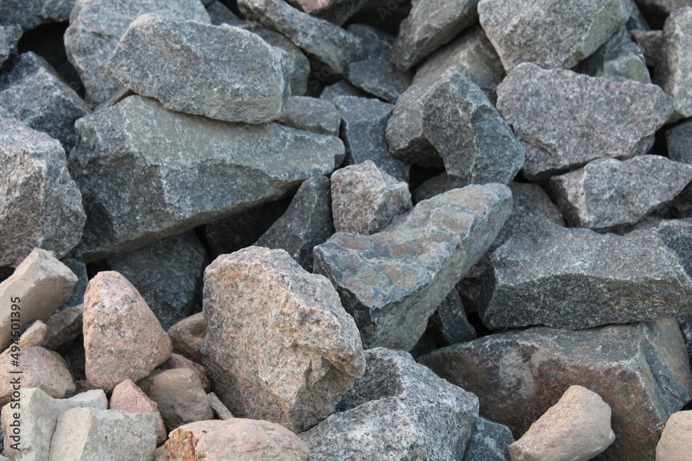 a background of cobblestone stones close-up. stones for the construction of the foundation. Crisis construction of expensive materials