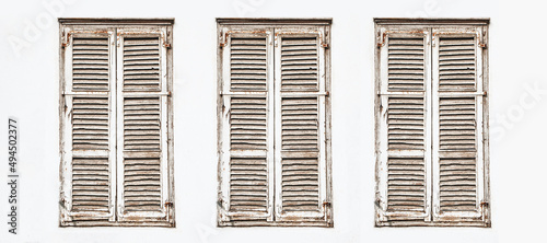 Wooden window shutter. Rustic frame window white paint wall. Closed window isolated. European style architecture background. Three windows isolated on white. Choose one of the three in a row.