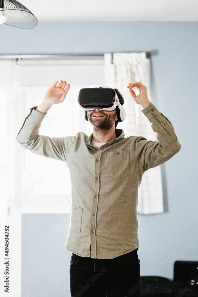 Young man exploring cyberspace in VR goggles at home Young man exploring cyberspace in VR goggles at home