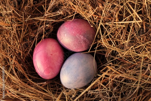 Eggs are bright, multi-colored in a straw nest. Easter concept, preparation for the holiday