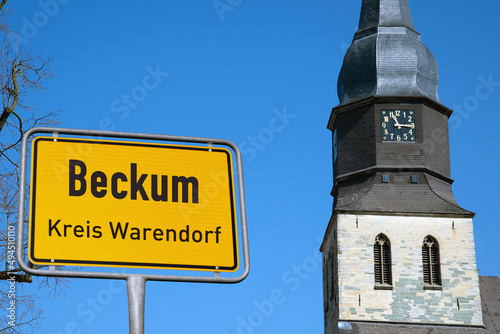 Ortstafel Beckum, Kreis Warendorf, St. Stephanus im Hintergrund photo