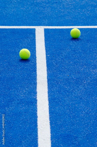 two balls and lines of a blue paddle tennis court © Vic
