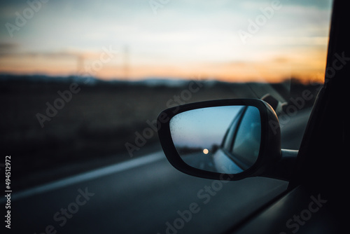 Car mirror with sunset sky reflection