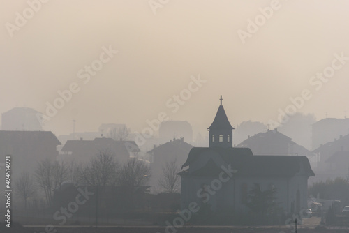 View of the small church in the city on a foggy day in Chivasso, Italy