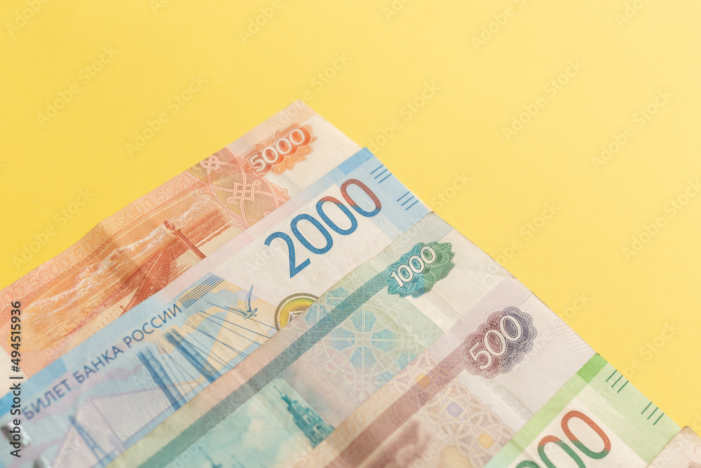Obraz premium Money of Russia. Banknotes and coins on yellow background. Close-up of Russian rubles of various denominations. Finance concept