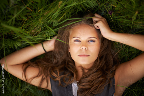 Shes one with nature. Portrait of a gorgeous woman lying on her back outside.