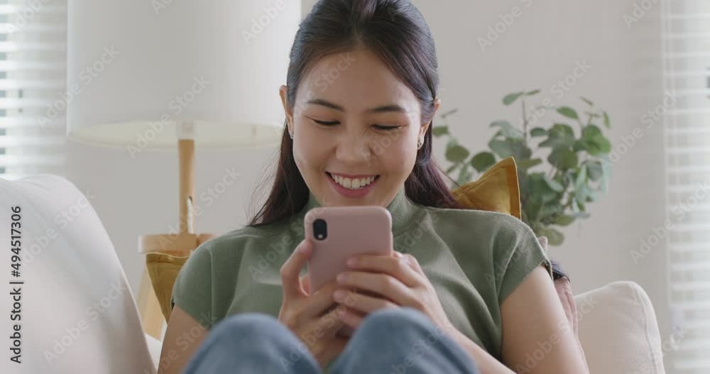 Young attractive beautiful casual asia female lady or student look at cellphone play social media IG reel tiktok app lying down at sofa couch living room feel relax comfort carefree at home apartment. Young attractive beautiful casual asia female lady or student look at cellphone play social media IG reel tiktok app lying down at sofa couch living room feel relax comfort carefree at home apartment.