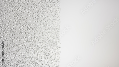 Medium size water drops blown off the half wet glass surface on grey background | Overlay foreground or background for shower hygiene and skin moisturizing beauty products