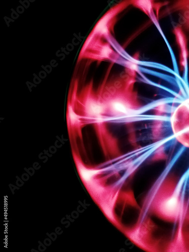 Decorative lamp in the shape of a plasma ball with red and blue tesla electrodes