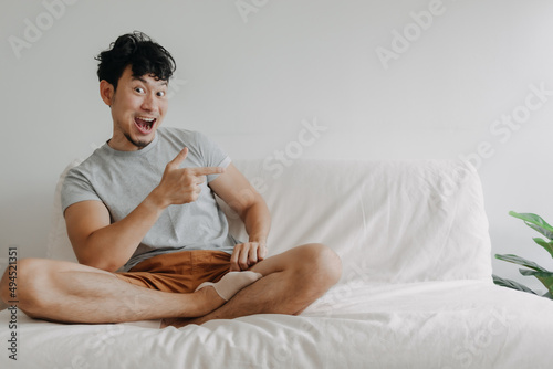 Asian man stop meditation and presenting content with funny wow face.