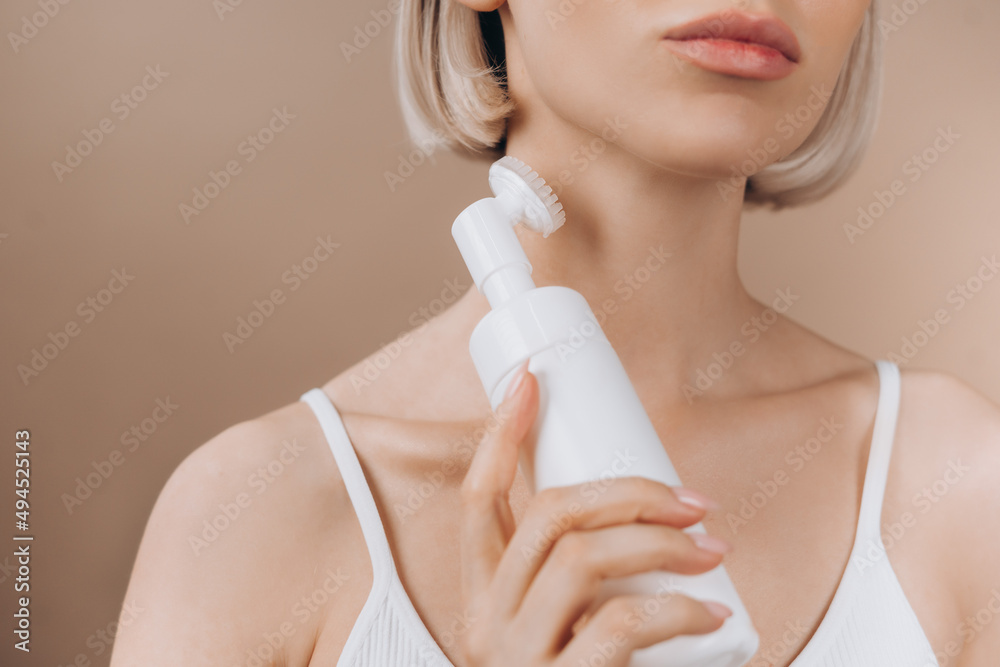 Unrecognizable woman with electronic face roller device doing skin rejuvenation massage. Concept of beauty and self care. Unrecognizable woman with electronic face roller device doing skin rejuvenation massage. Concept of beauty and self care.
